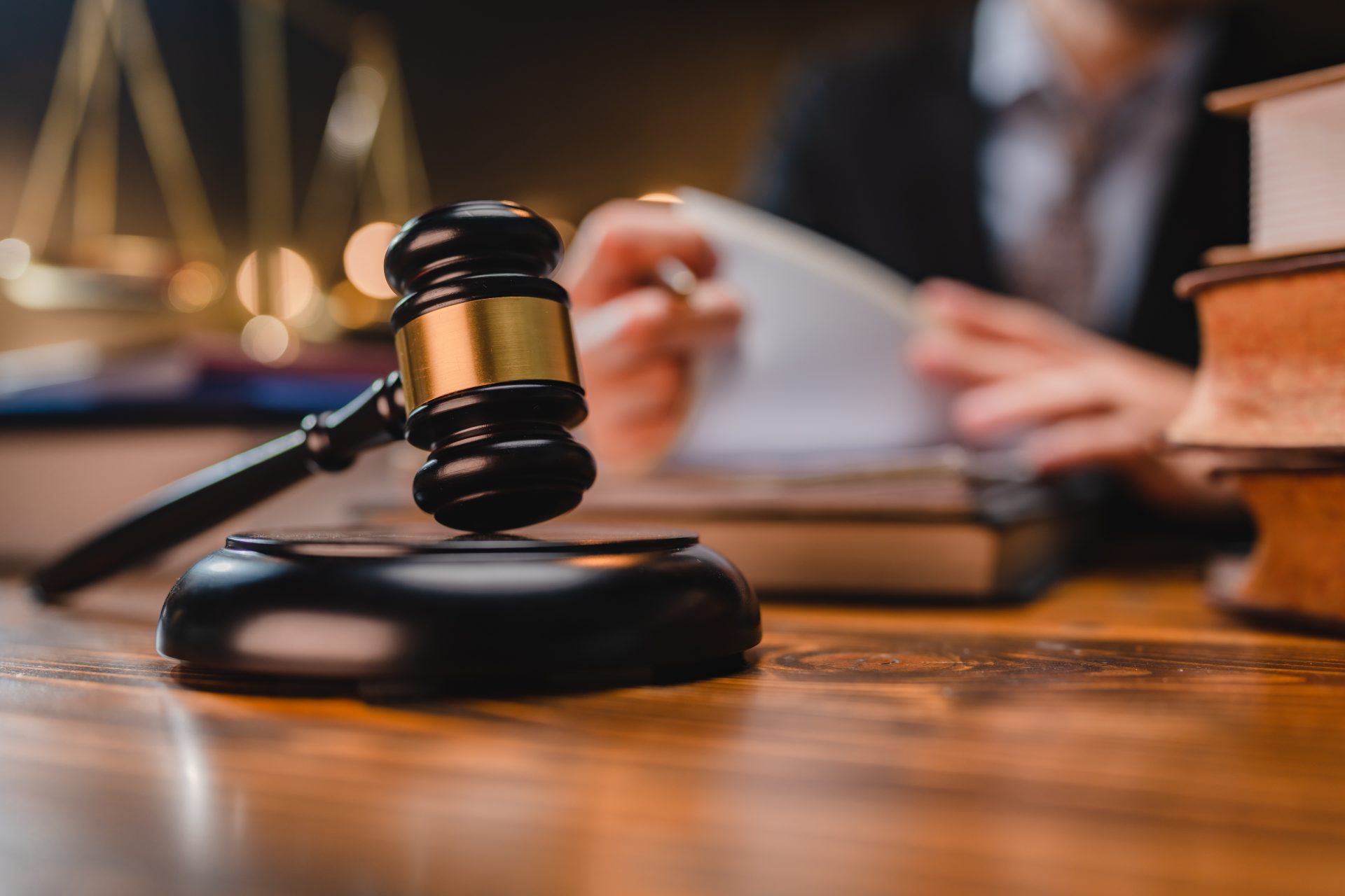 Gavel on wooden desk with legal books and blurred scales of justice in background, representing the Texas DUI trial process and jury deliberations.